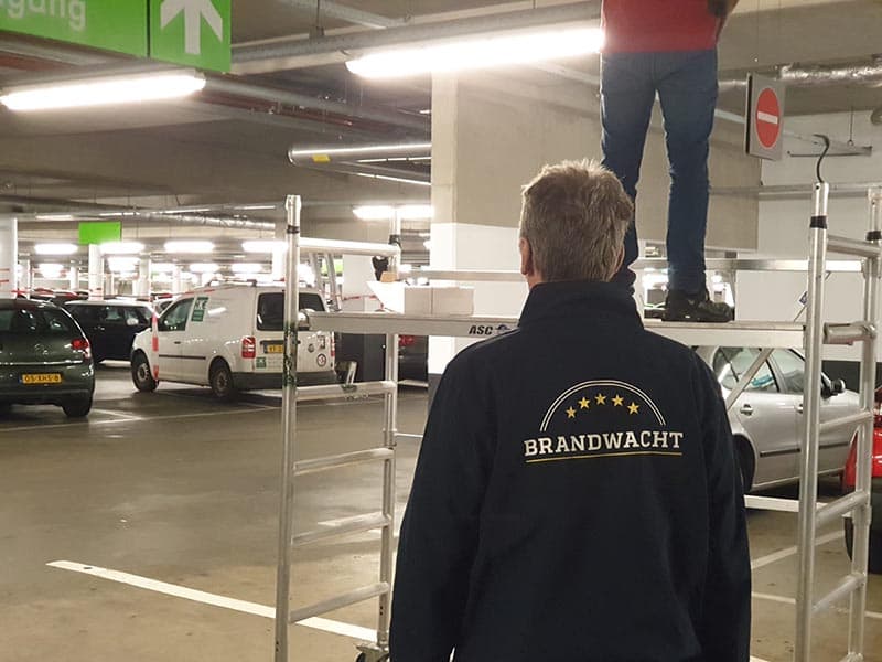 Voorkom brand bij werkzaamheden! Een brandwacht van Risk Safety is aanwezig tijdens het vervangen van de brandmeldcentrale (BMC) in een parkeergarage